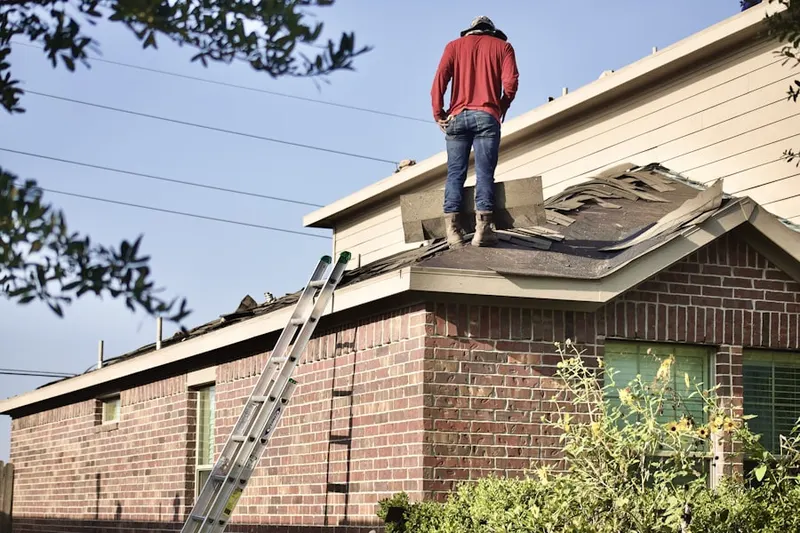 Professional roofer working on a residential roof in Mead